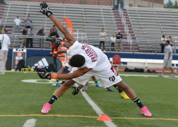 A camper stretches during Robert Griffin III's first-ever "Friday Night Lights" football camp at Anacostia Senior High on Friday, June 13.