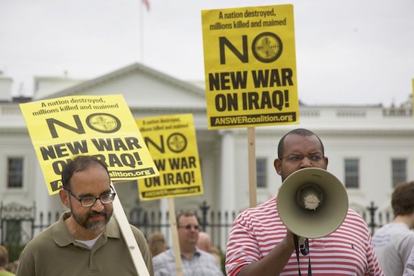 Eugene Puryear (right), a Green Party candidate for an at-large seat on the D.C. Council, speaks through a megaphone in front of the White House on June 21 during a demonstration against new military action in Iraq.