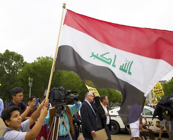 Yassin Allalak, an 11-year-old boy from Iraq, raises the flag of his home nation in front of the White House on June 21 during a demonstration against new military action in Iraq.