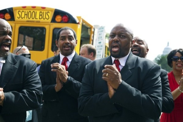 A group named No Chains sings as a bus containing original members of the Freedom Riders heads to Richmond, Virginia, for a June 2 ceremony to commemorate the 50th anniversary of the Civil Rights Act.