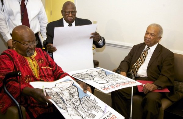 Freedom Riders John Moody, Charles Person and Rev. Reginald Green sign posters during a June 2 ceremony at a U.S. Department of Education facility in Richmond, Virginia, to commemorate the 50th anniversary of the Civil Rights Act.