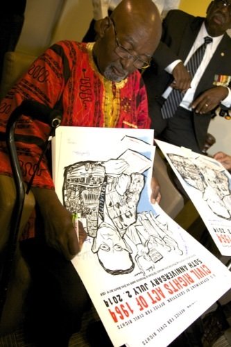 Freedom Rider John Moody signs posters during a June 2 ceremony at a U.S. Department of Education facility in Richmond, Virginia, to commemorate the 50th anniversary of the Civil Rights Act.