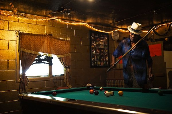 Melvin Williams, 64, plays pool in Odessa's Place, a small one-room bar in the impoverished Baptist Town neighborhood of Greenwood. Odessa Nicks, 85, opened the bar in 1963 and has kept it going in old age so that she remains occupied. Williams pays $200 a month in rent to live in an apartment directly behind the bar. (Edmund D. Fountain, special to ProPublica)