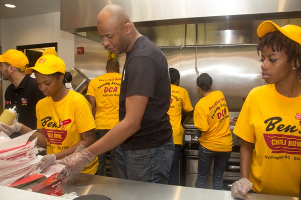 Ben's Chili Bowl employees serve up chili dogs during the celebration of the restaurant's newest location at National Airport in Arlington, Va., on Wed., July 23.