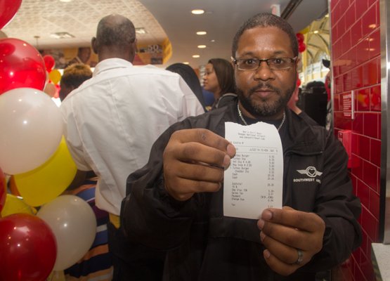 Southwest Airlines employee Alan Pauls shows off his receipt as the first patron at Ben's Chili Bowl's newest location at National Airport in Fairfax, Va., on Wed., July 23.