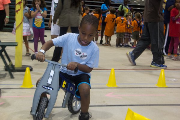 Quincy Kennard navigates a small bike on an obstacle course at the Thingamajig Conference hosted by the YMCA of Metropolitan Washington at Show Place Arena in Upper Marlboro, Md., on Thurs., July 24.