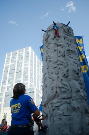 A 3-year old climbs this 25 foot rock-wall all by himself as friends, family and onlookers cheer him on. #HarlemWeek (08/17/2014)