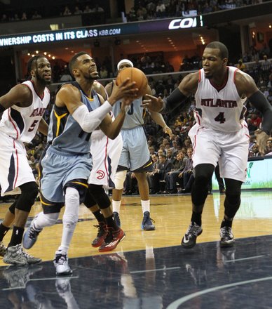 Mike Conley’s drive to the basket yields a positive result despite the defense of Paul Millsap of the Atlanta Hawks. (Photo: Warren Roseborough)