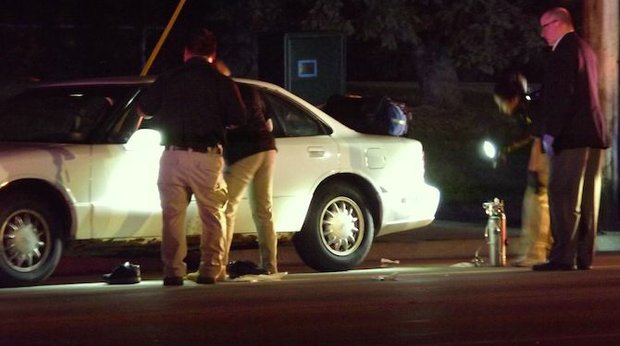 Police peer into the car that Philando Castile was riding in as a passenger when he was shot multiple times by an officer making a traffic stop in Falcon Heights, near the gates to the Minnesota State Fair grounds.. (Photo: Harry Colbert, Jr./Insight News)