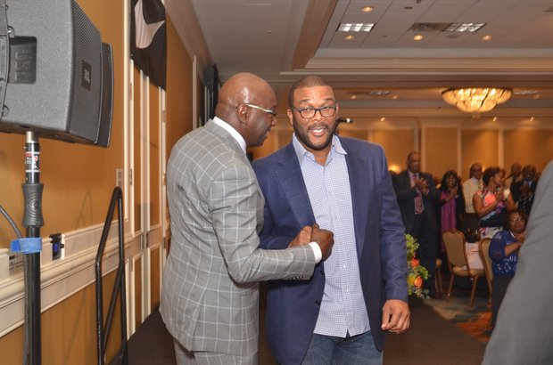 Left: Tyler Perry (right) greets Nike exec Willie Gregory at the Coaches’ Luncheon. (Photo: Tyrone P. Easley)
