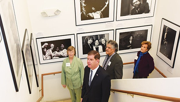 Mayor Martin Walsh attends a gallery opening for Don West, “Portraits of Purpose”, at the Boston Center for Adult Education. Behind are BCAE Executive Director Susie Brown, West and his wife Libbie Shufro.