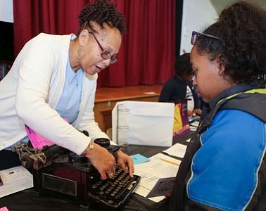 Member of Zeta Phi Beta Sorority, Inc., with attendee Ashley Ward at the "Typewriting Machine" - Lee Burridge and Newman Marshall station. -- Photo by April A. Ward