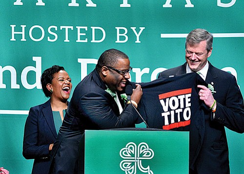 With typical satirical humor, mayoral candidate Tito Jackson (center) unveils a campaign t-shirt to the crowd at the annual St. Patrick’s Day Breakfast as Gov. Charlie Baker and State Sen. Linda Dorcena Forry look on. This year marks the fourth consecutive year that the senator has hosted the event.