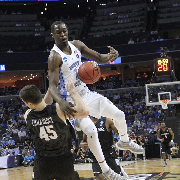 Andrew Chrabascz of Butler takes a charge from Theo Pinson of North Carolina.