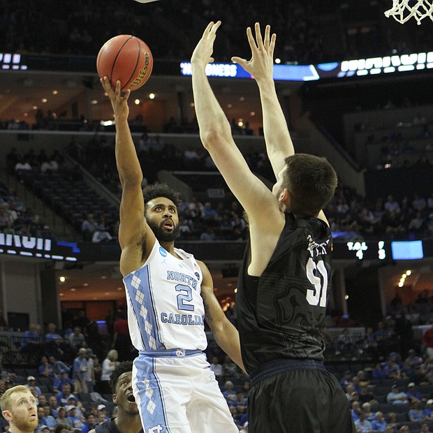 Joel Berry of North Carolina (left) shoot and scores over Nate Fowler of Butler.