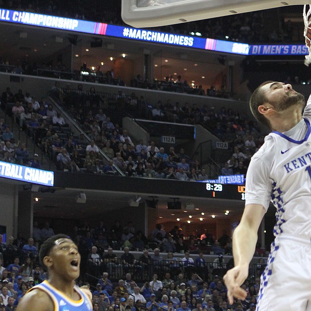 Gyorgy Goloman of UCLA (right) dunks on Isaiah Briscoe of Kentucky.