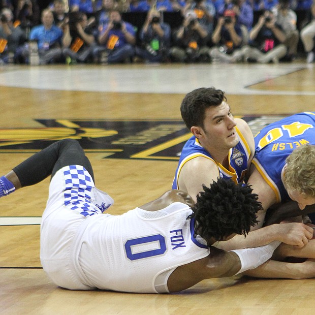 Kentucky and UCLA players battling for the loose ball.
