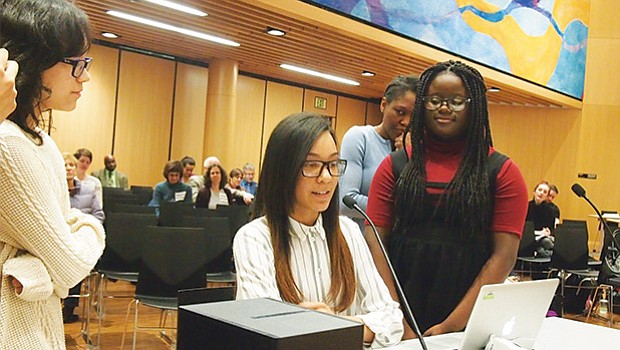 Surrounded by fellow members of the John W. McCormack debate team, Genesis Valdez speaks to the Boston School Committee about how the team garnered the best win-loss record in the Boston Debate League.