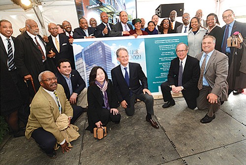 Investors, politicians, community organizers and project team members gather around the unveiled view of the proposed hotel to be built across from the downtown Boston Convention and Exhibition Center. The project, in part, has been to create a new model of unprecedented representation by minority- and women-owned businesses, infusing the Boston economy with a new business diversity. Gov. Charlie Baker, Lt. Gov. Karyn Polito, Mayor Marty Walsh and Massport CEO Tom Glynn also joined in the celebration of the $550 million, 1000-room hotel.