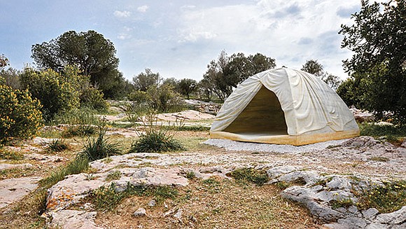 On a hilltop overlooking the Acropolis in Athens, Greece, a tent stands in a clearing among olive trees. Its folds ... On a hilltop overlooking the Acropolis in Athens, Greece, a tent stands in a clearing among olive trees. Its folds ...