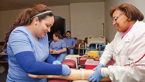 Students in our Phlebotomy Technician Program practice on tourniquets before completing live draws.