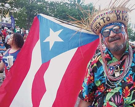 Edwin Rivera displays an abundance of Puerto Rican flags.
