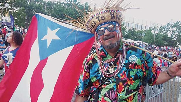 Edwin Rivera displays an abundance of Puerto Rican flags.