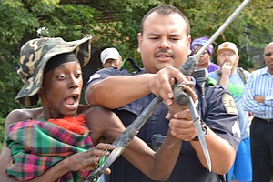 Corporal B. Ledezma, with the Dallas Police Department, attempts to disarm the woman, who is later arrested without further incident, Aug. 2. The episode represents the hazardous situations described by Ibrahim Abdullah of the Beacon of Light Community Outreach Service Center as “happening every day” in tent city.