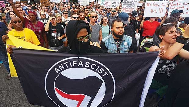 A protestor holds an “Antifacist Action” sign. Groups identifying as antifacist, or “antifa,” recently have drawn media attention for willingness to physically oppose white supremacists.