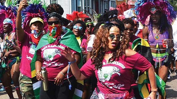 Members of the Soca & Associates masquerade band dance on Warren Street during Boston’s Caribbean Carnival.