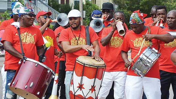 Members of a Haitian band use drums and improvised horns and percussion instruments.