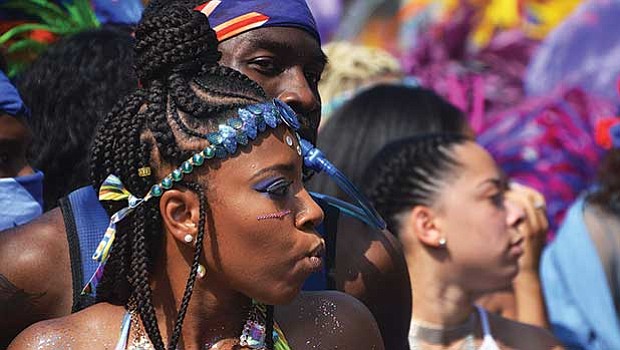Spectators and masqueraders mingle during Carnival.