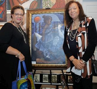 Willa Chisler and Pamela James pictured next to one of the silent auction paintings, "Girl In Blue" Limited Edition on GICLEE by Lyonel Laurenceau.