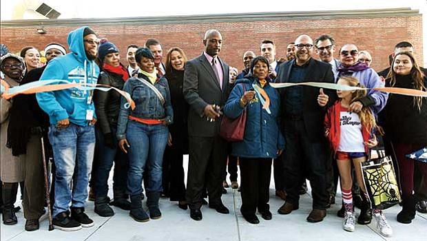Elected officials and community members cut the ribbon to re-open The Yard at the Tobin Community Center. The $950,000 renovation provides community members an out-door meeting space, which has been dedicated to the late Ida Graves.
