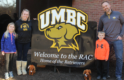 The Woelper family showed their support for their favorite basketball team by posing with UMBC mascot "True Grit the Retriever." (Left to right) Brenna Woelper, Colleen Woelper, Brodie Woelper and Jason Woelper. Colleen and Jason are both graduates of UMBC.

