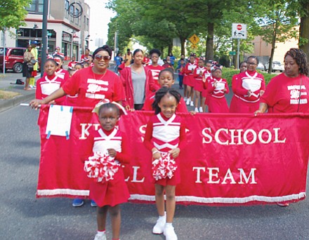 The younger King Sun School Drill team marches with a banner of school pride.