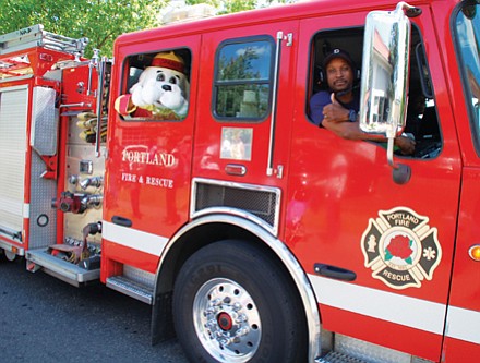 A Portland Fire and Rescue firefighter and his fluffy friend are thumbs up for Portland’s freedom parade.
