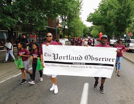 Representatives of the Portland Observer, Oregon’s longest continuous minority-owned newspaper, march down Martin Luther King Jr. Blvd.
