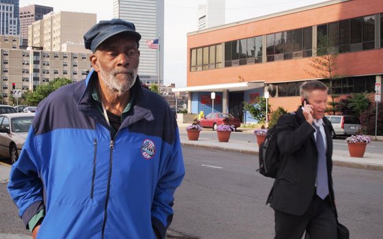 Mel King stands across the street from the former site of his childhood home, now the headquarters of... Mel King stands across the street from the former site of his childhood home, now the headquarters of...