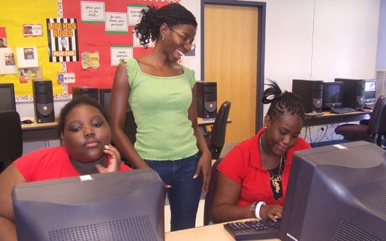Good News program coordinator Nicole Daley (standing) gives writing advice to Francesca Durocher (left) and Ieysha Smith (right)... Good News program coordinator Nicole Daley (standing) gives writing advice to Francesca Durocher (left) and Ieysha Smith (right)...