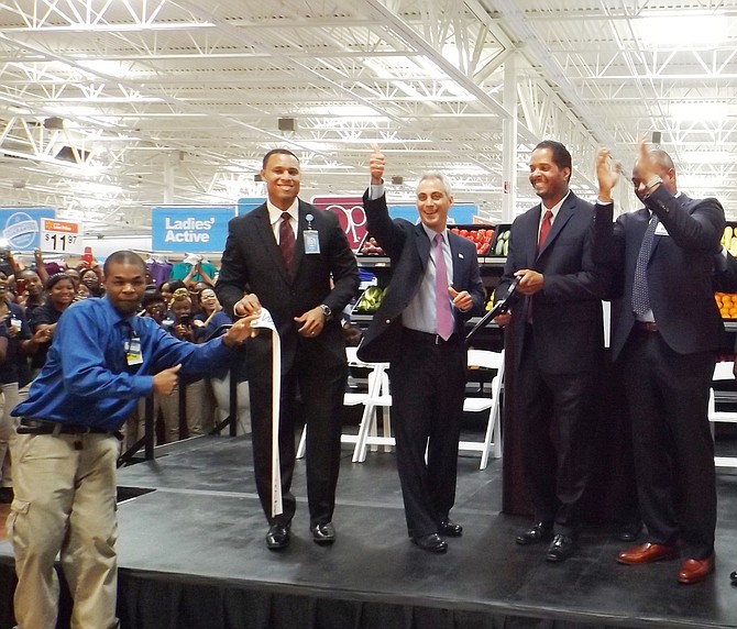 A Walmart associate held the ribbon as (L-R) Cedric Clark, Walmart Rep.; Chicago's Mayor, Rahm Emanuel and Chicago 9th Ward Ald., Anthony Beale cut the ribbon during a pre-grand opening Tuesday afternoon at the new Pullman Walmart Supercenter. 