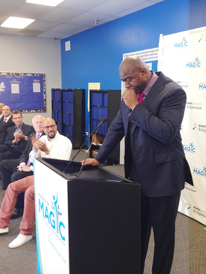 An emotional Earvin “Magic” Johnson speaks about his desire to help at-risk youth in need of an education as entertainer Common (middle) and Ill. Gov. Pat Quinn look on.