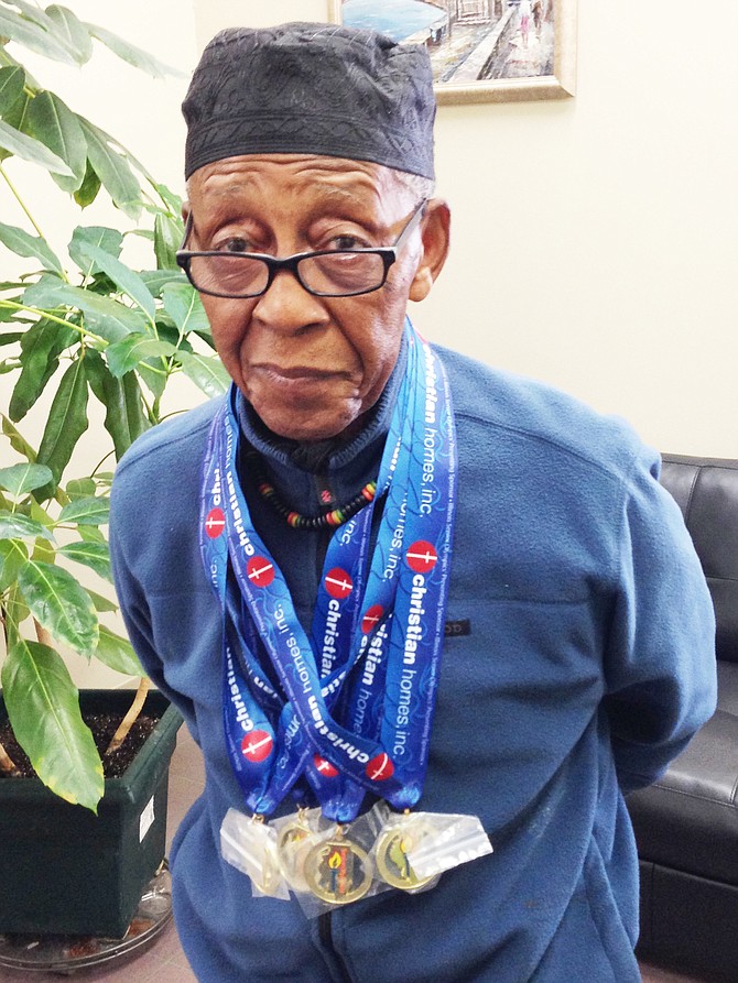Baba Griot Leonard Lucas poses with his most recent Illinois Senior Olympic gold medals.