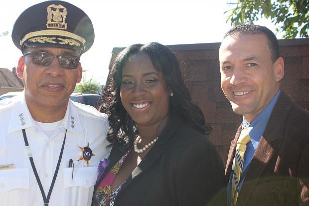 (L-R): Village of Dolton Chief John Frankling, App developer Victoria Gatling, and Village of Dolton Deputy Chief, Abe Martinez pose during a press conference about the I Alert U app.  The I Alert U app, which was developed by Gatling, will allow Dolton residents to alert the Village of Dolton Police Department of illegal activity with their smartphones.  