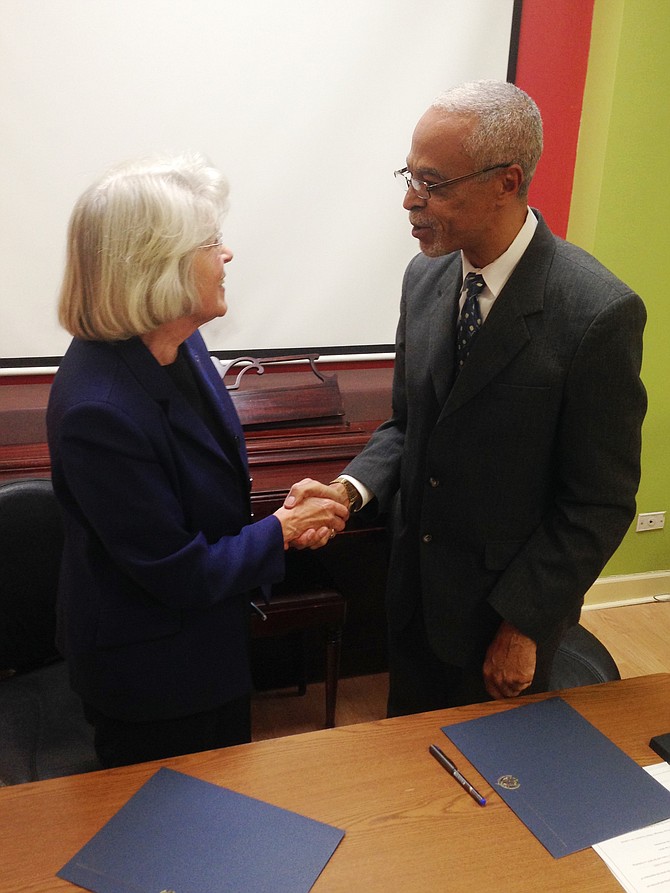 Dr. Sharon K. Hahs, President, Northeastern Illinois University and A. Patrick Augustin, Executive Director, Pan-African Association shake hands after establishing an official partnership between their respective organizations.  