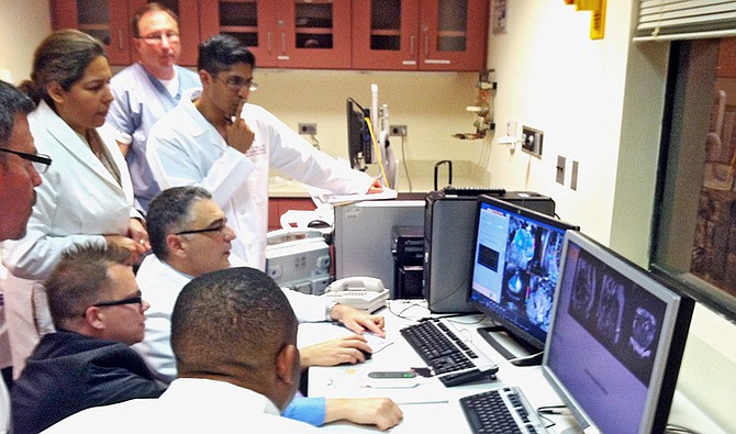 A new experimental procedure known as MRI-guided HIFU, uses magnetic-resonance imaging to focus heat-generating, high-intensity ultrasound onto fibroid tumor growths in women. Real-time MRI scans guide the ultrasound procedure and monitor temperatures in and around targeted tissues. Shown: Dr. Aytekin Oto and Nathaniel Crump of the University of Chicago monitor the MRI-guided HIFU procedure with the rest of the team.