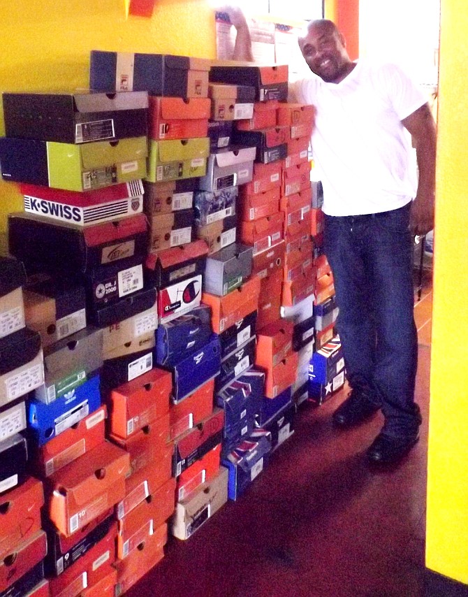 Leo Holmes, manager at Chicago Wingz Around the World, 557 E. 75 St., pictured with the boxes of donated shoes for his Sunday event where he provides free food and clothing to those who are homeless or in need.