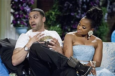 This 2014 image released by Bravo shows Apollo Nida, left, and his wife Phaedra Parks, cast members on "The Real Housewives of Atlanta," during the taping of a reunion special in Atlanta. Federal prosecutors said Tuesday, July 8, 2014, that 35-year-old Nida has been sentenced to eight years in prison after pleading guilty to federal fraud charges. He was also ordered to pay restitution to victims of a $2.3 million scheme during his sentencing hearing in U.S. District Court in Atlanta. Nida is the husband of Phaedra Parks, one of the reality show's stars. He pleaded guilty May 6 to conspiring to commit mail, wire and bank fraud.