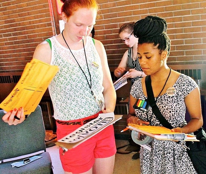 Chicago Votes, a non-partisan, nonprofit organization that encourages young adults to get involved in the electoral process, has set a goal of registering 25,000 individuals ages 18-35 – particularly people of color- to vote in the Chicagoland area. Chicago Votes field organizer, Breanna Champion, (above-left), speaks with a fellow Chicago Votes member before registering voters at Chicago’ recent Gay Pride Parade. 