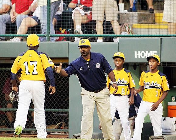 Jackie Robinson West All-Stars Little League (JRW) Manager Darold Butler congratulates JRW player, #17 Joshua Houston, as he makes his way to the dug-out during the Little League World Series at Williamsburg, PA.  